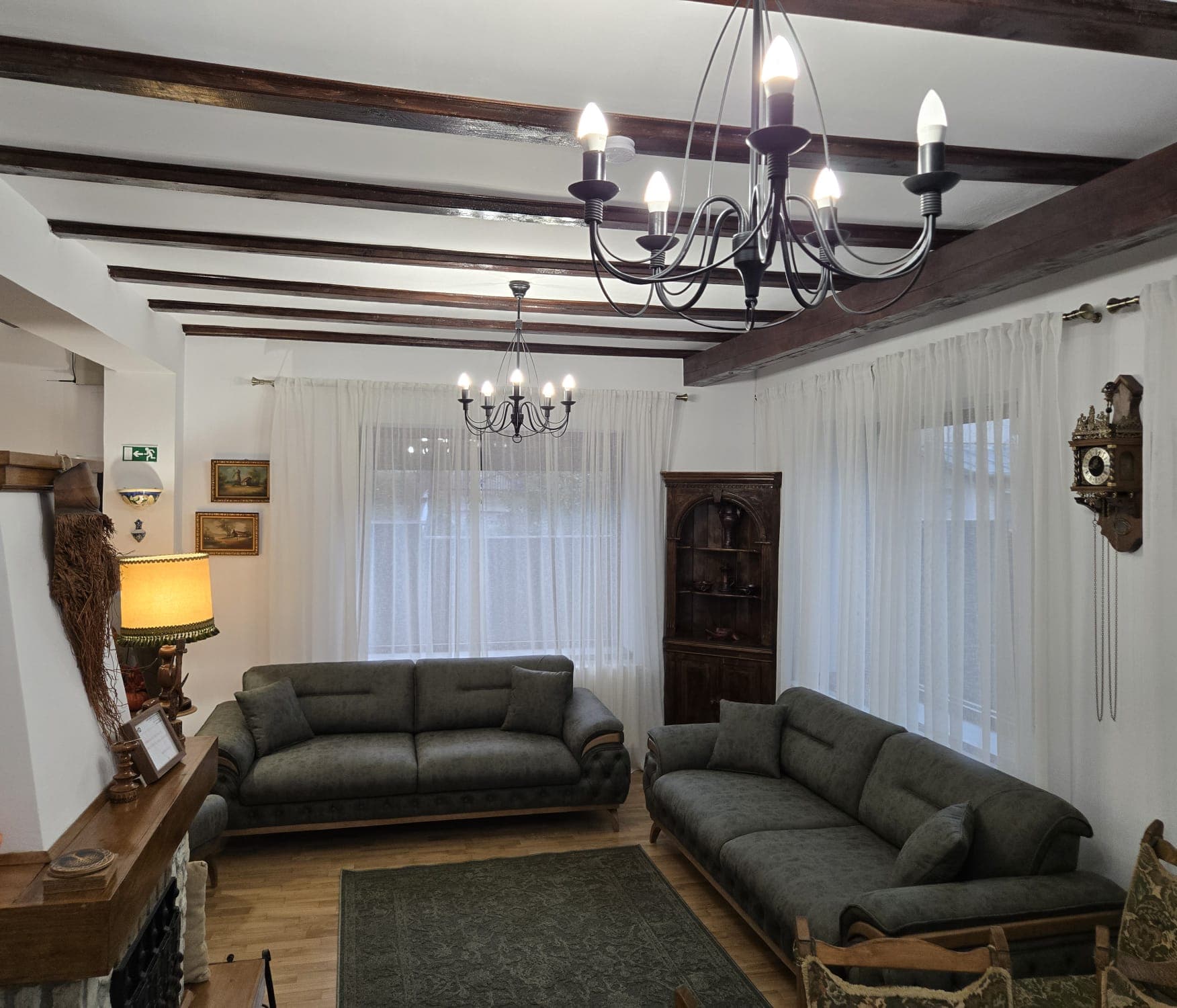 Livingul cu două canapele și candelabre de fier forjat
