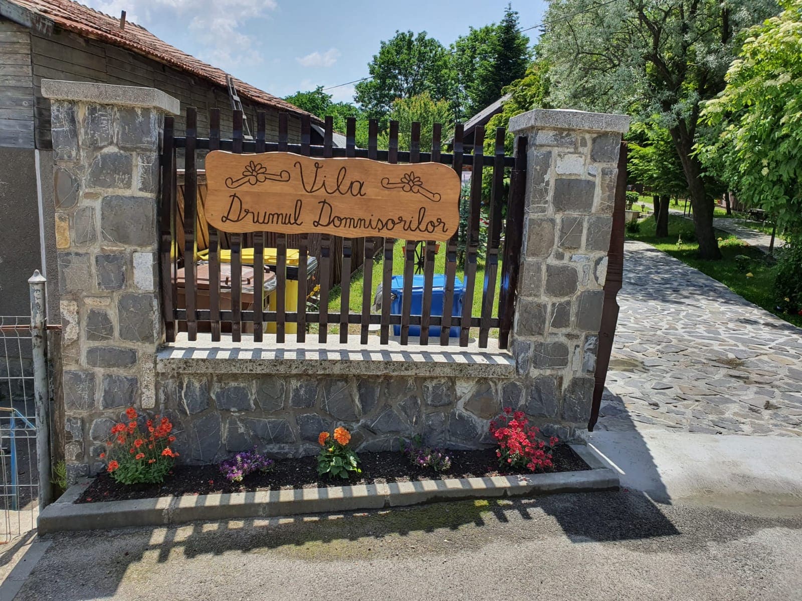 Poarta de piatră cu firma sculptată în lemn a Vilei Drumul Domnișorilor